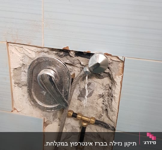 ברז מקלחת חשוף עם צינור מתכת בקיר פתוח